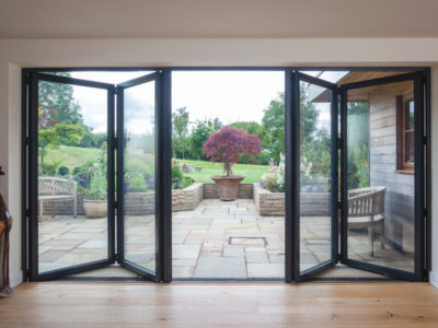 black bi-folding doors opening up into the garden of a home