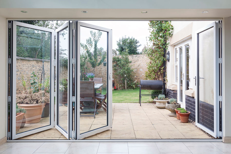 white visofold 1000 doors opening into the garden of a home
