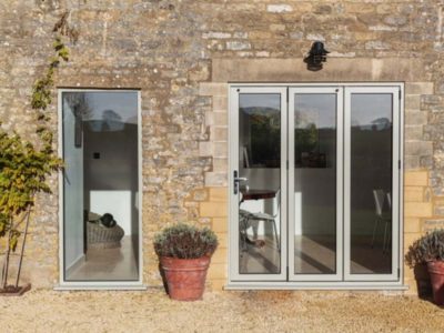 slimline light grey bi-folding doors shot from the outside of a home