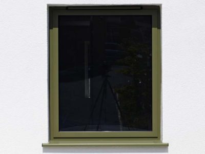 singular khaki green casement window on a white wall
